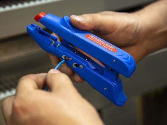Blue tool with red cap being used by a person on a blurred background