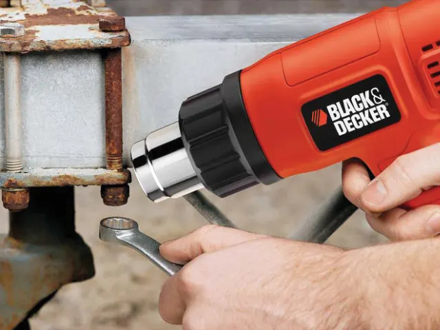 Person using a Black & Decker drill on a metal surface