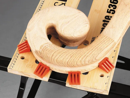 Wooden dowel with a circular hole on a wooden block with measurement markings.