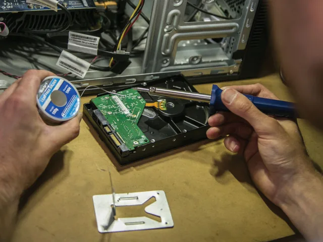 Person working on a computer internal components with a screwdriver and thermal paste.