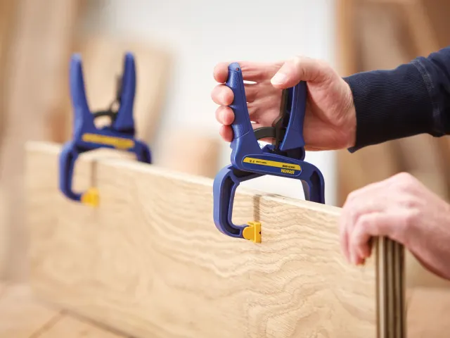 Person using a Kreg Jig tool on wooden furniture