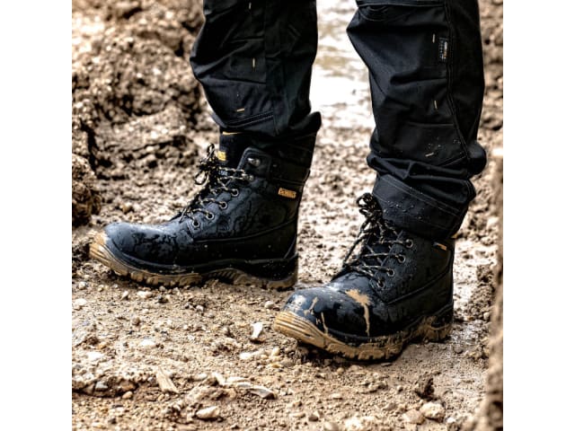 Black boots and pants on a muddy ground
