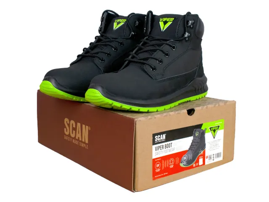 Black safety boots with green accents on a cardboard box labeled 'SCAN'.