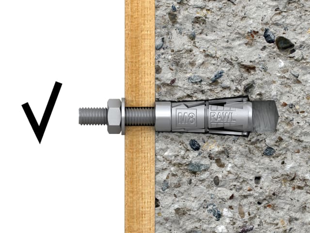 Metal drill bit on a wooden stick against a concrete background