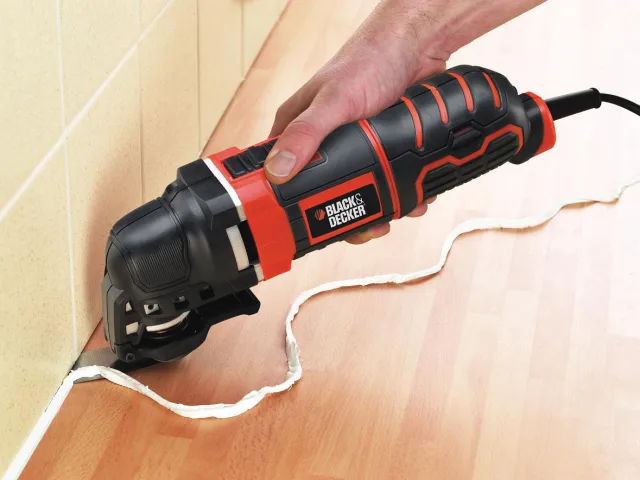 Black and Decker oscillating tool being used to cut a piece of wood.