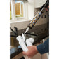 Person applying silicone sealant to a kitchen faucet