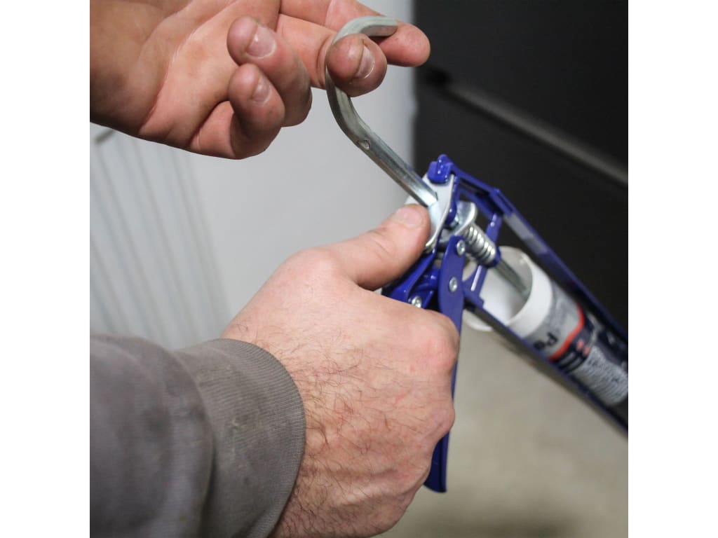 Person using a caulking gun to apply sealant