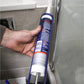 Person applying caulk to a bathroom corner with a tube of caulk.