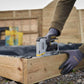 Person using a power tool on a wooden structure outdoors