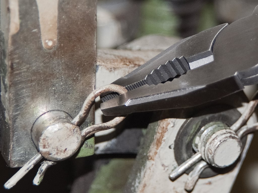 Multitool with various tools attached to a metal surface