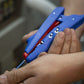 Close-up of hands using a blue tool with a red component.
