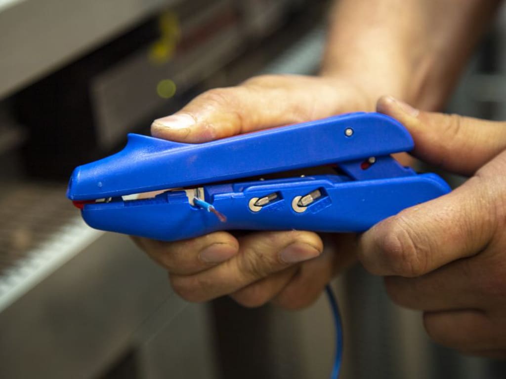 Person holding a blue stapler with a blurred background