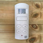White electronic device with buttons on a wooden surface
