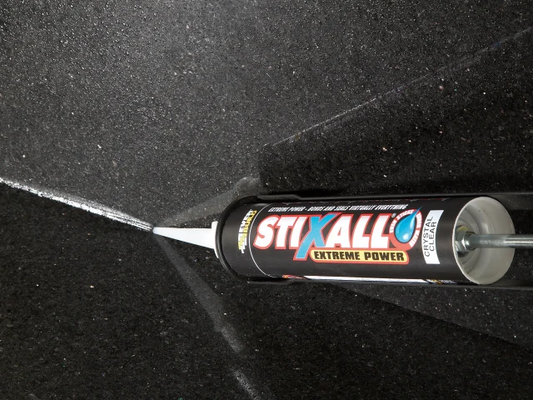 Stixall Extreme Power adhesive tube on a black surface