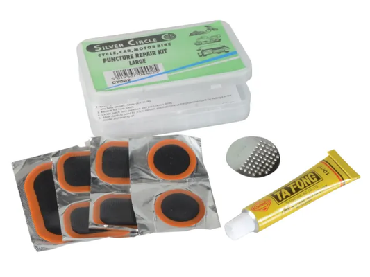 Puncture repair kit with patches, glue, and tools on a white background