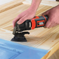Person using a Black & Decker oscillating tool on a wooden surface