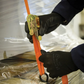 Person using an orange ratchet strap on a wrapped package