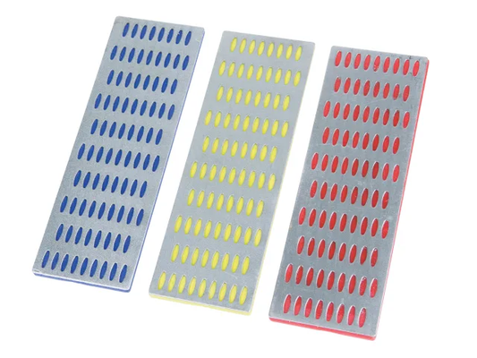 Three rectangular sanding blocks with blue, yellow, and red patterns on a white background