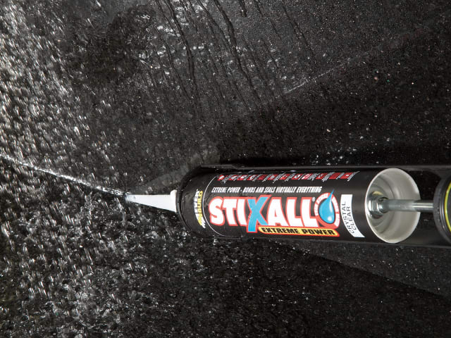 Stixall extreme power adhesive tube on a black textured surface