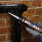 Person applying STIXALL Extreme Power sealant to a brick wall