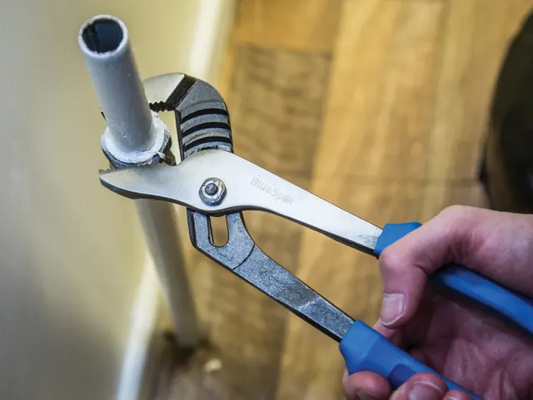 Pliers holding a pipe with a blurred background