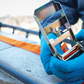 Person wearing blue gloves holding a reflective metal object with a blurred outdoor background
