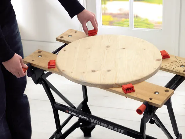 Woodworking workbench with adjustable legs and a circular wooden platform, featuring the Black & Decker brand.