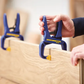 Person using a Kreg Jig tool on wooden furniture