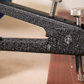 Close-up of a metal tool with textured handle and metallic components on a blurred background