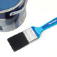 Paintbrush with blue handle next to a paint can on a white background