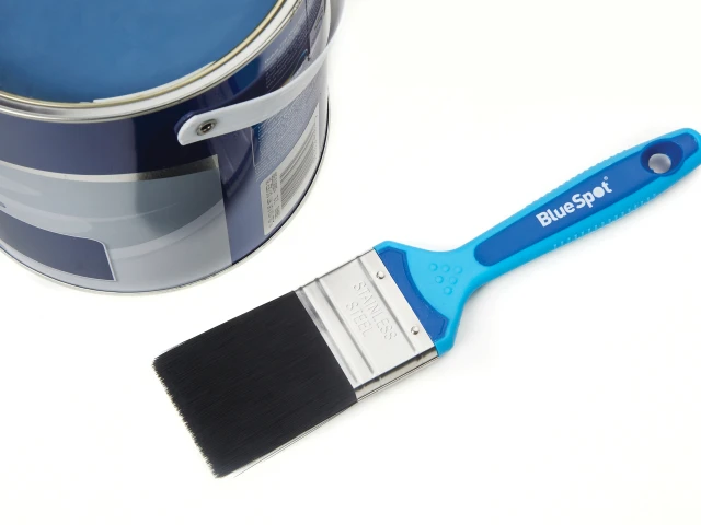 Paintbrush with blue handle next to a paint can on a white background