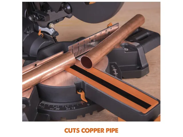 Copper pipe being cut by a miter saw on a wooden surface