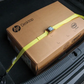 HP desktop box in a car trunk with a yellow strap