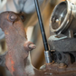 Close-up of a mechanical component with rust and a tool inserted