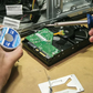Person repairing a computer with tools and components on a table
