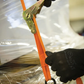 Person cutting orange strap with pliers on a reflective surface