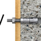Metal drill bit on a wooden stick against a concrete background
