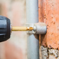 Drill bit attached to a drill bit adapter, drilling into a brick wall.