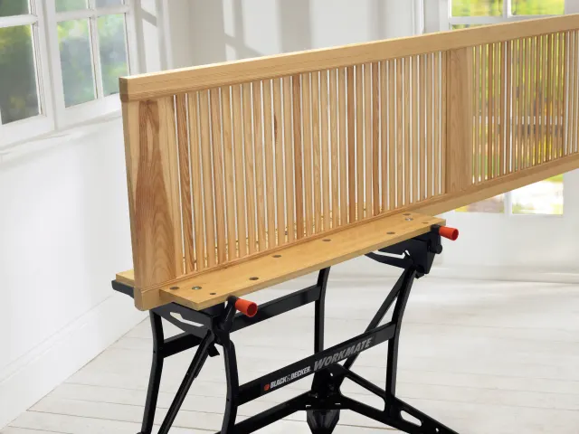 Wooden panel on a clamp in a bright room with large windows