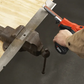 Person using a power tool on a wooden surface