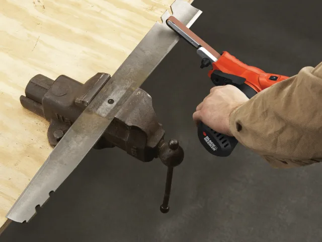 Person using a power tool on a wooden surface