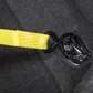 Close-up of a yellow strap with a black buckle on a dark fabric background