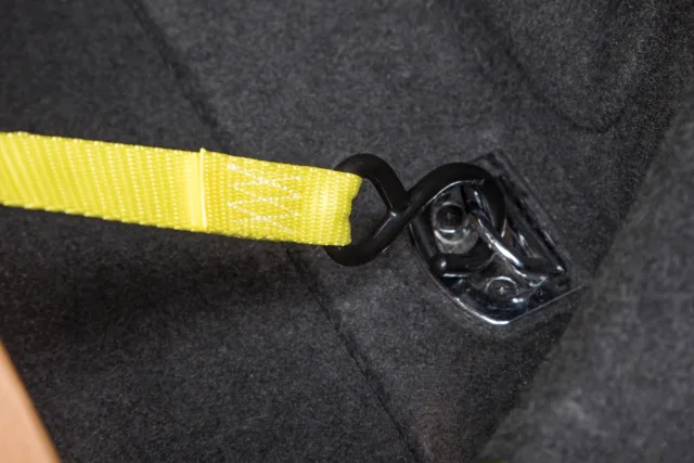 Close-up of a yellow strap with a black buckle on a dark fabric background