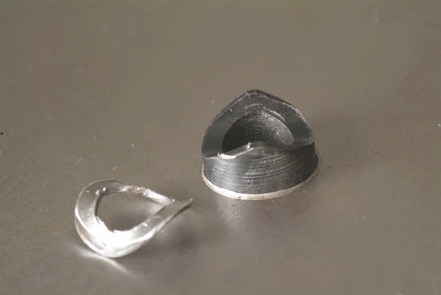 Two metallic objects on a gray surface