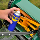 Person using WD-40 on a lawn mower