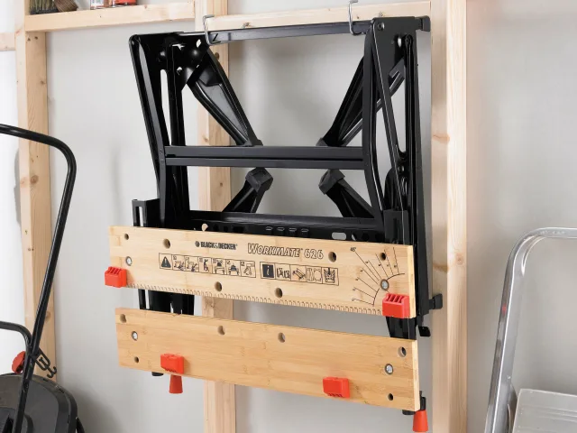 Woodworking tool with ruler and measurements on a wooden stand against a white wall.