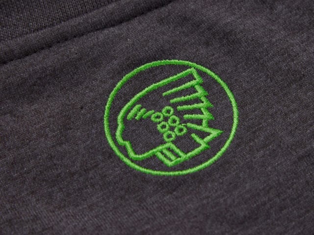 Green embroidered logo on a dark fabric background